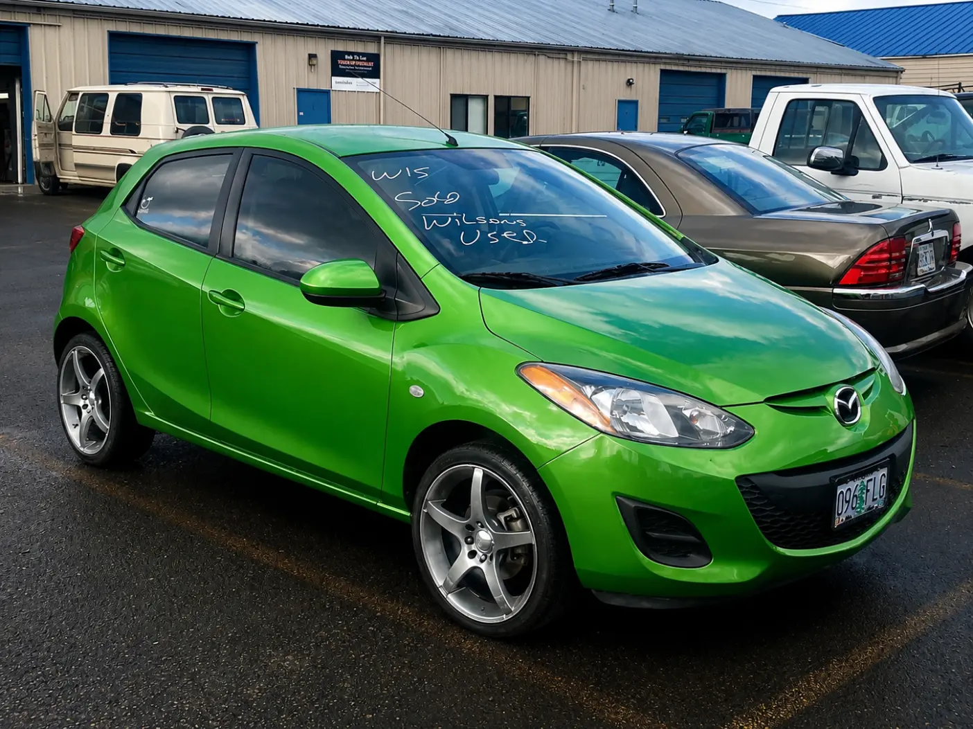 Green four-wheel vehicle parked at a dealership lot for auto body service in Eugene, OR