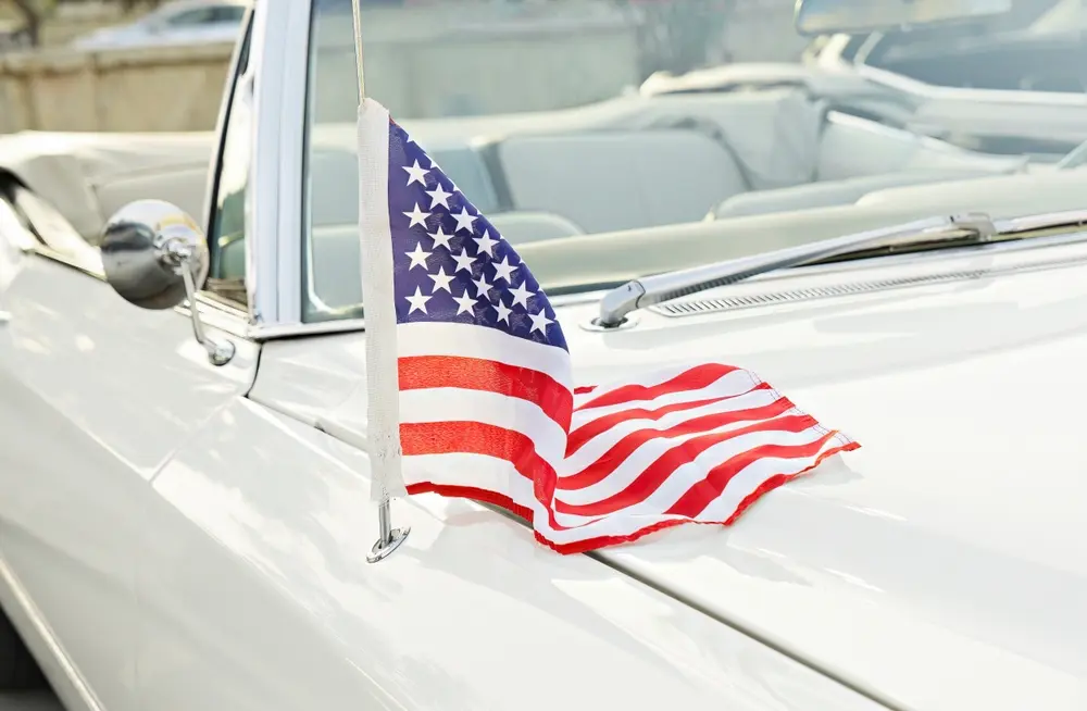 White car with a small USA flag receiving auto body repair services in Eugene, OR